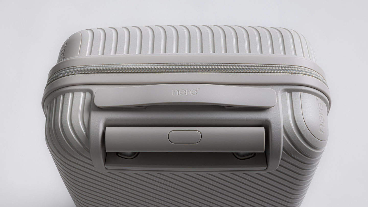 Top-down view of a grey hardshell suitcase showing handle and lock