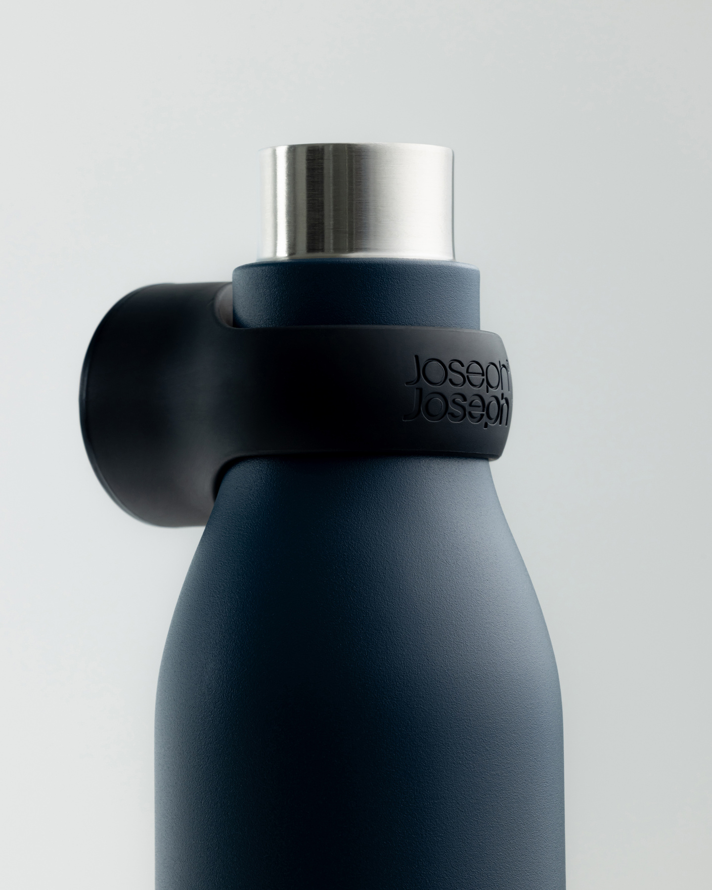 Close-up of a dark blue water bottle neck with attached black collar cap