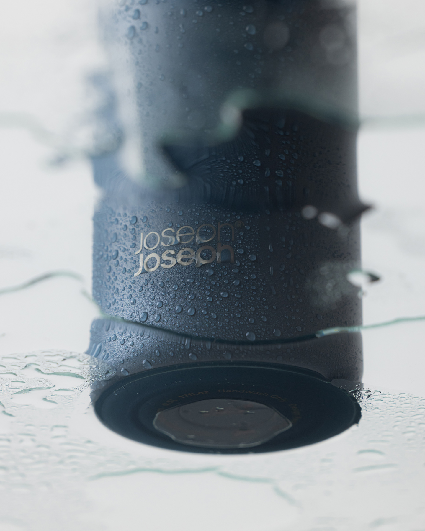 Inset view of dark blue water bottle base resting on a surface