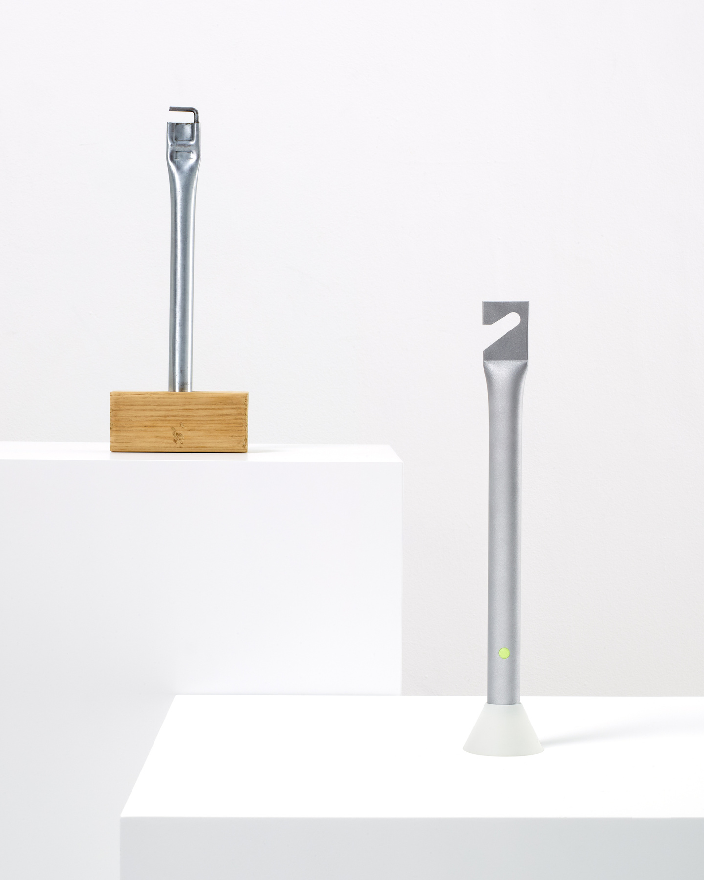 Two metallic prototype objects displayed on separate white plinths