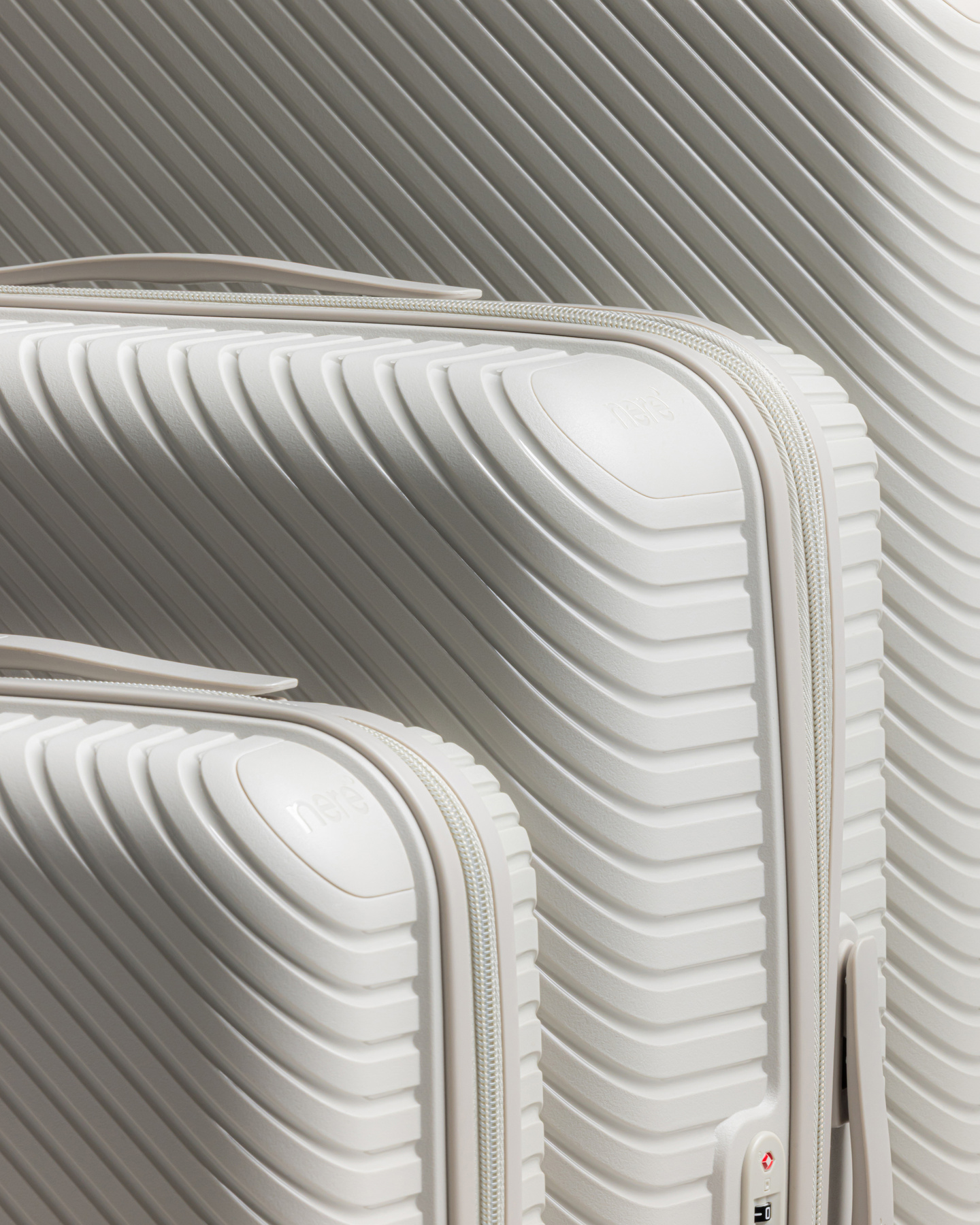 Close-up inset view of white hardshell luggage corners
