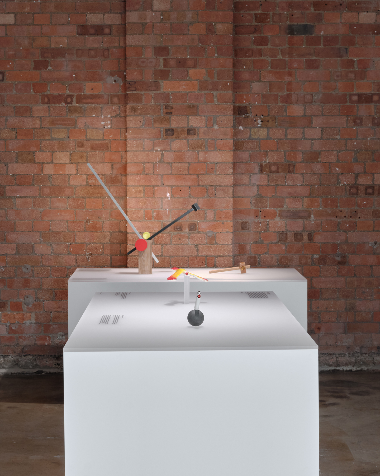 White pedestals with exhibition materials in front of exposed brick wall background