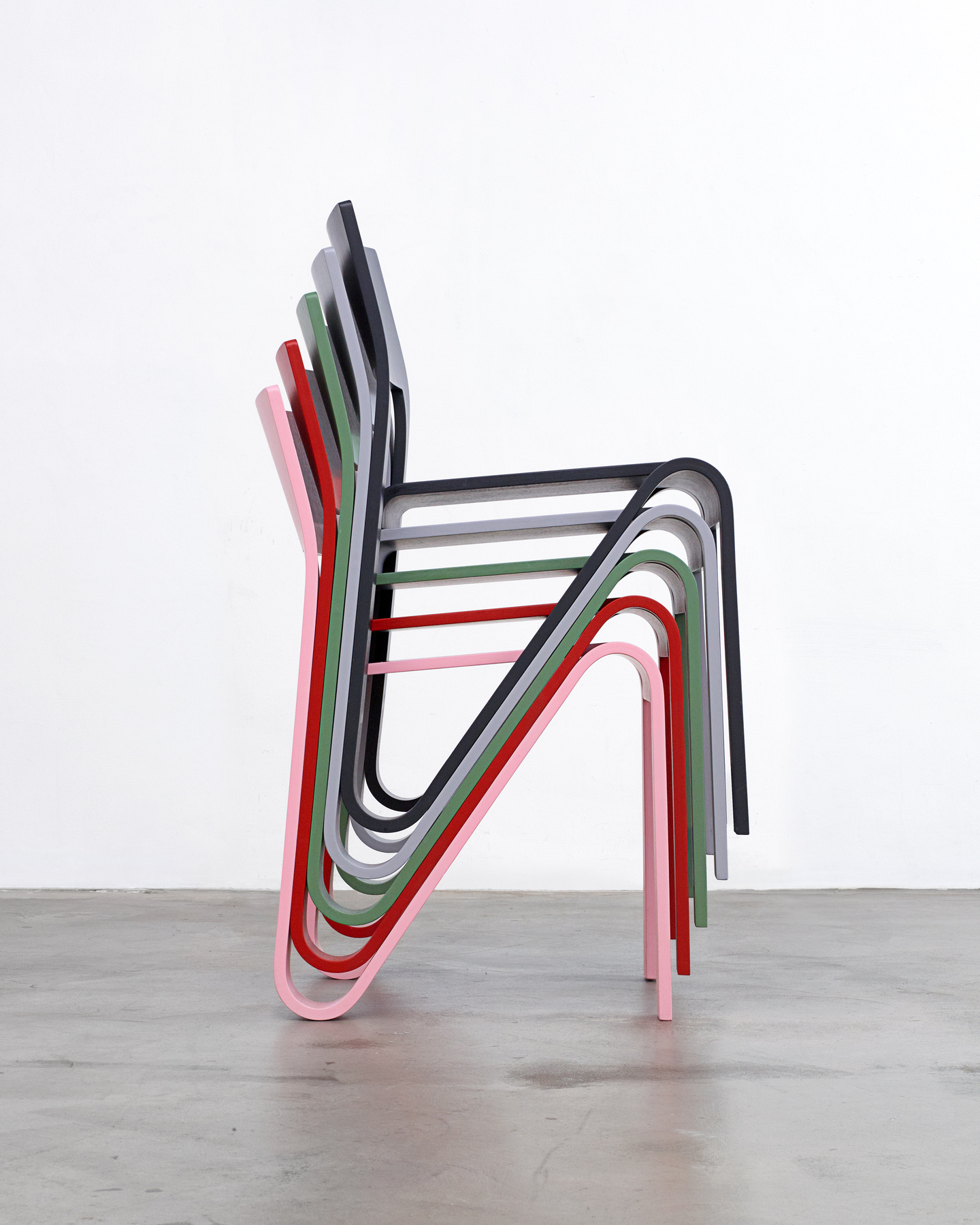 Side view of a compact stack of wooden chair frames.