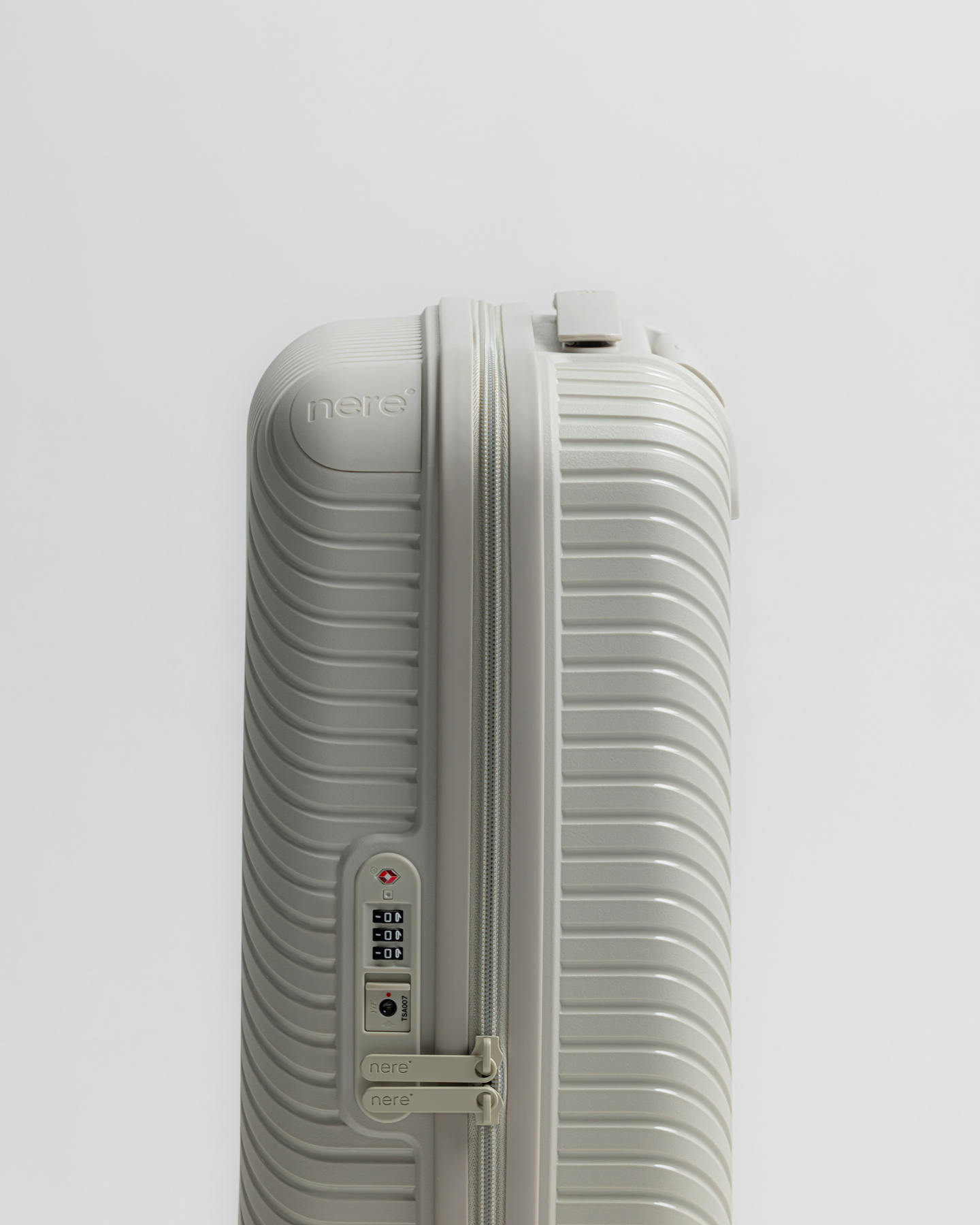 Side view of a grey suitcase showing zip closure and lock mechanism