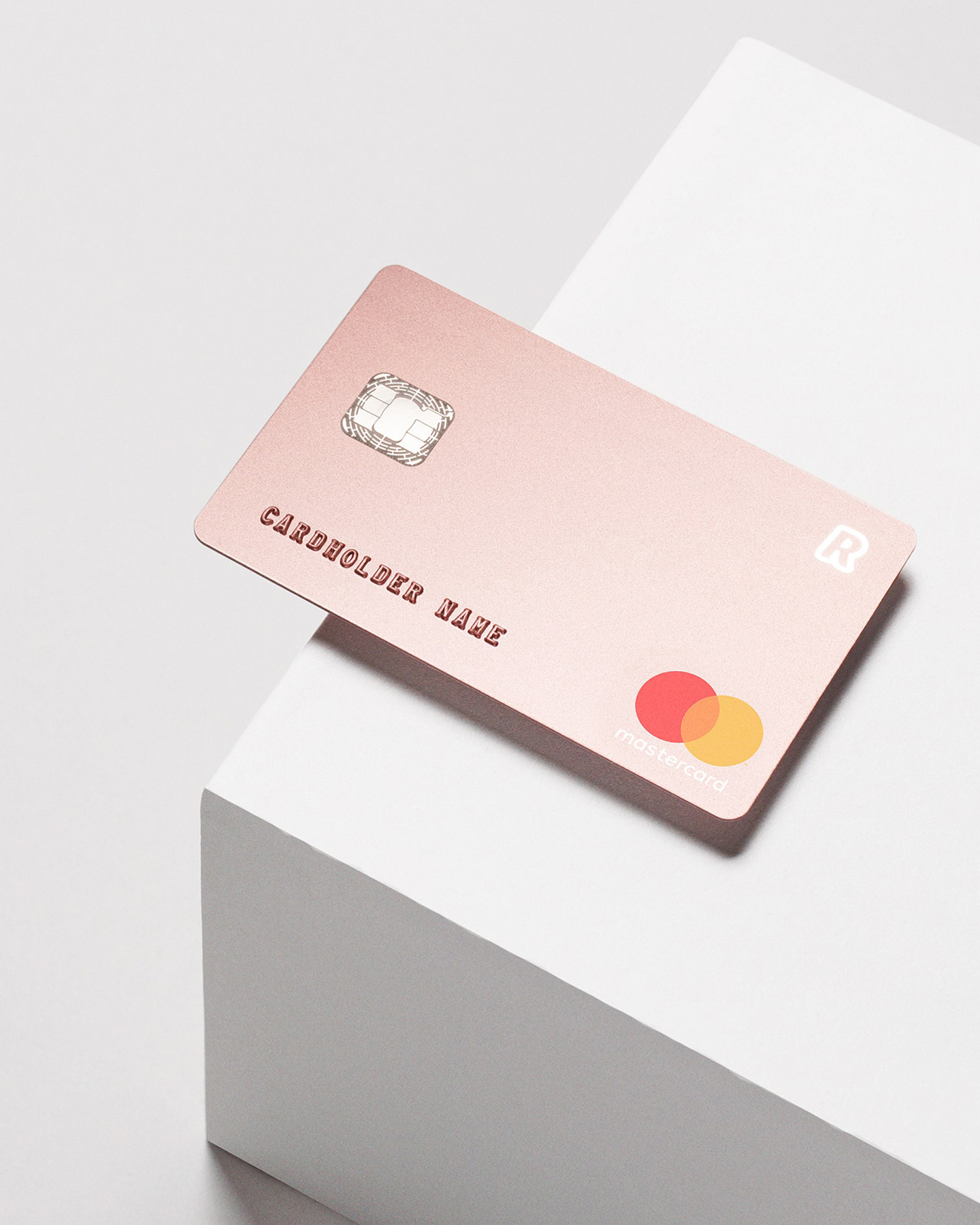 Rose gold Revolut Premium card resting on a white geometric block.